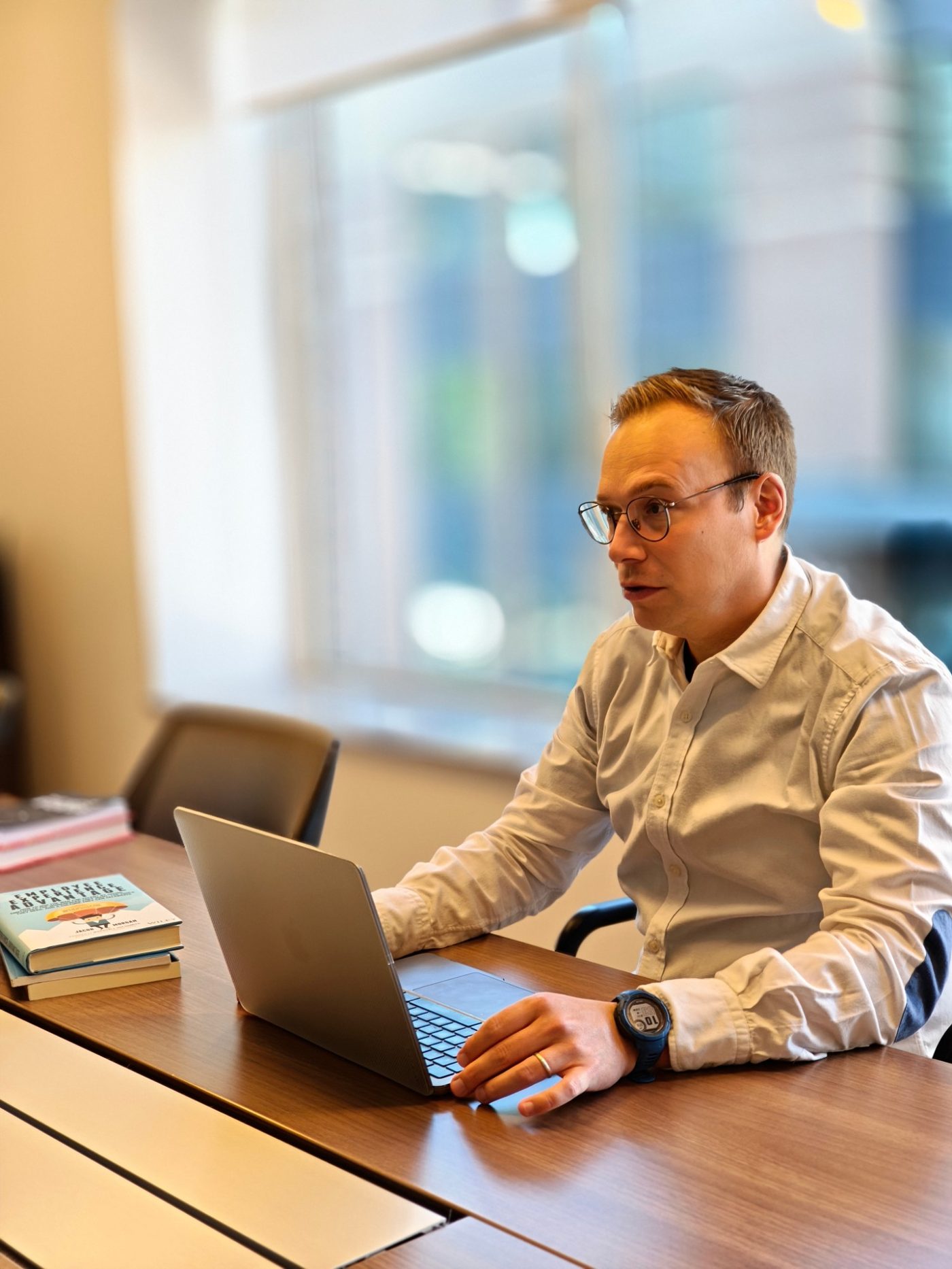 Cristijn Cambr&eacute; aan de telefoon, naast een stapel boeken over employee experience